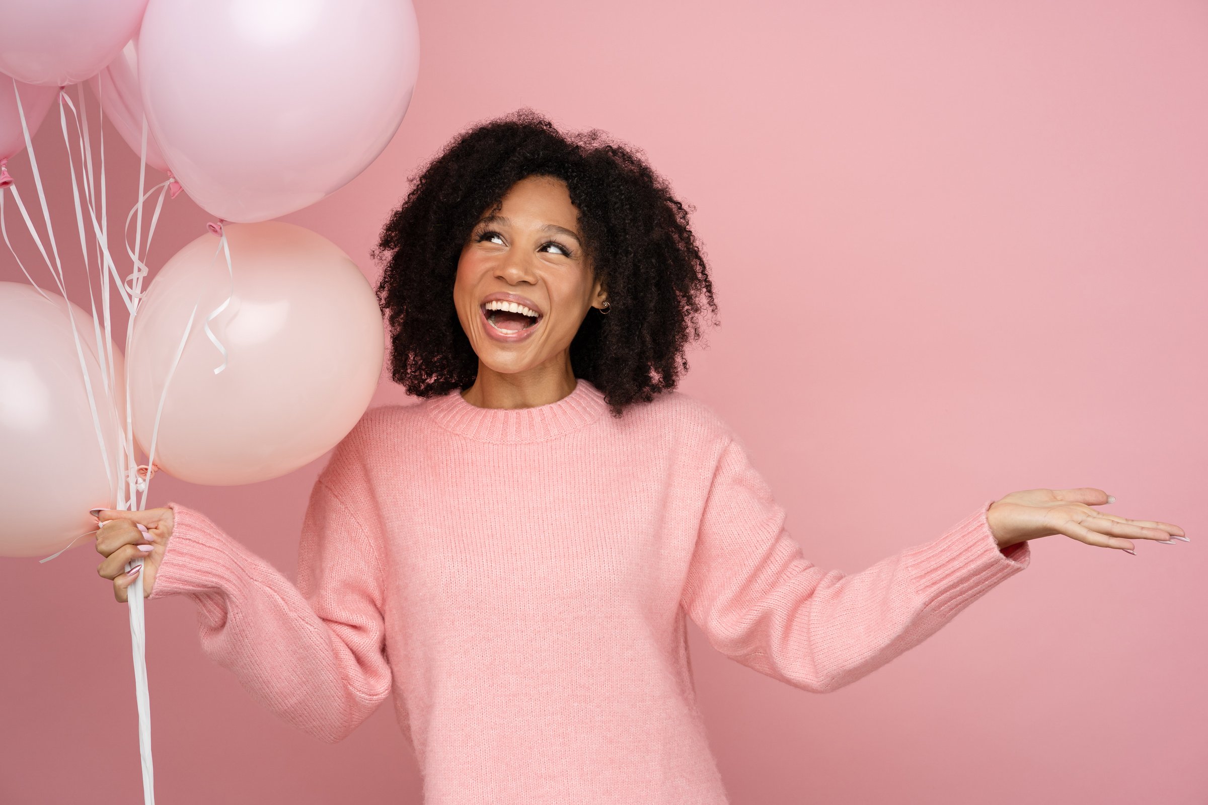 Portrait of a Happy Woman Holding Pastel Pink Balloons